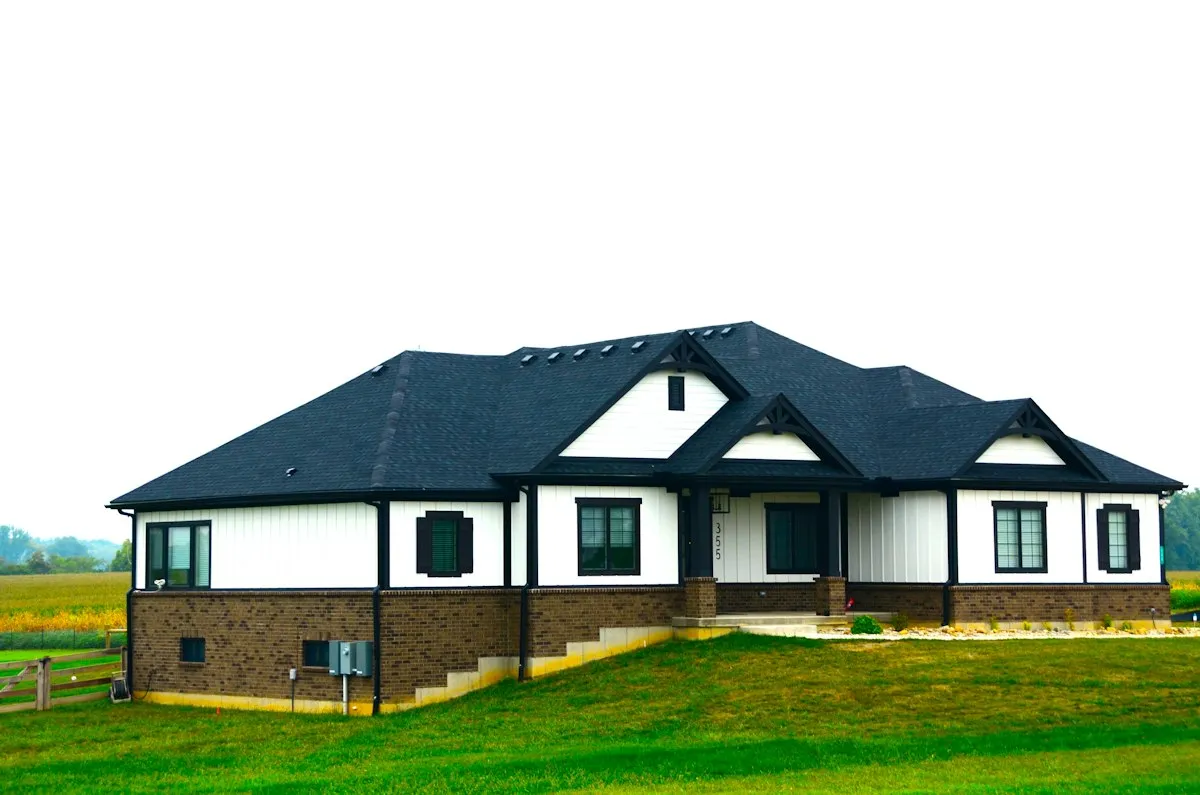 Black 6-inch K-style seamless aluminum gutters on a modern farmhouse roofline with matching black downspouts
